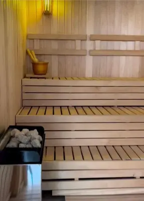 a sauna with wooden steps and a bowl of rocks at Apart France - Monoambiente con piscina y estacionamiento in Río Cuarto