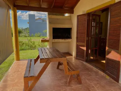 a wooden bench on a patio with a fireplace at Cabañas Amore Mío in Mina Clavero