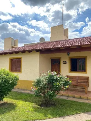 a house with a bench in front of it at Cabañas Amore Mío in Mina Clavero