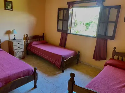 a bedroom with two beds and a window at Cabañas Amore Mío in Mina Clavero