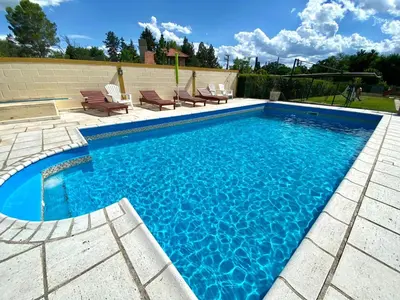 a swimming pool with blue water in a backyard at Cabañas Amore Mío in Mina Clavero