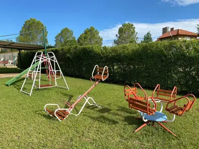a group of playground equipment sitting in the grass at Cabañas Amore Mío in Mina Clavero