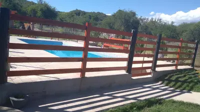 a wooden fence next to a swimming pool at Susurro de Montaña in San Lorenzo