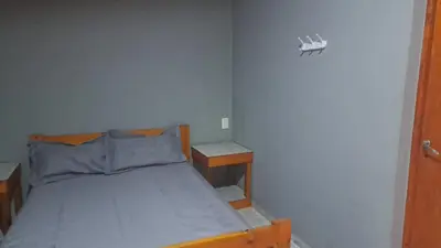 a small bedroom with a bed and two tables at Susurro de Montaña in San Lorenzo