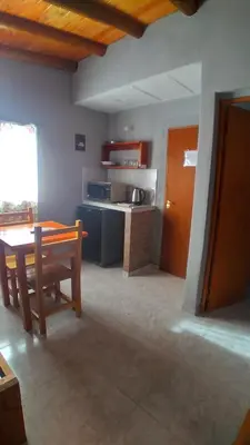 a kitchen with a wooden table and a kitchen with a counter at Susurro de Montaña in San Lorenzo