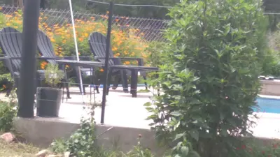 two chairs and a table in a garden at Susurro de Montaña in San Lorenzo