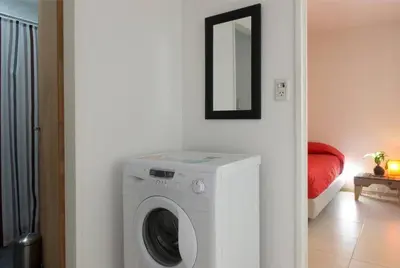 a white washing machine in a room with a mirror at RELÁJATE Y DISFRUTA DE LA MEJOR ZONA DE CORDOBA. in Cordoba