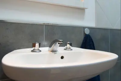 a white sink in a bathroom with a mirror at RELÁJATE Y DISFRUTA DE LA MEJOR ZONA DE CORDOBA. in Cordoba