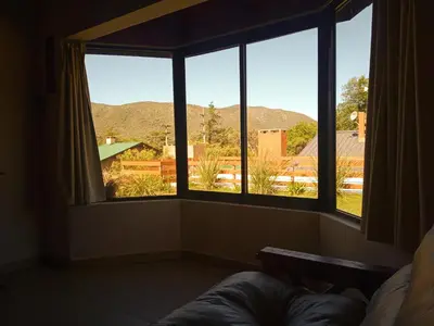 a room with three windows with a view of the mountains at Cabañas Puentes Amarillos in Santa Rosa de Calamuchita