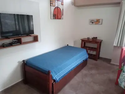 a bedroom with a bed and a flat screen tv at Cabañas Puentes Amarillos in Santa Rosa de Calamuchita