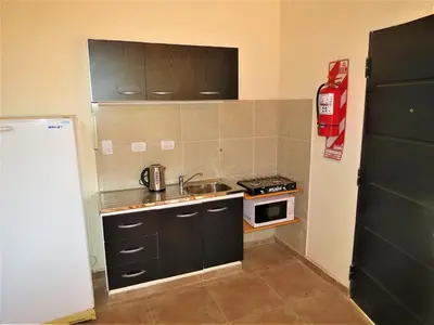 a small kitchen with a sink and a stove at Cabañas Puentes Amarillos in Santa Rosa de Calamuchita