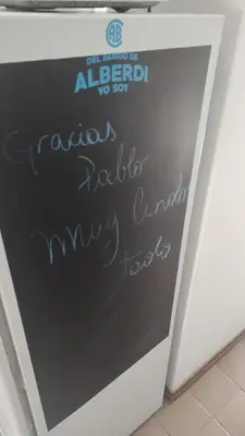 a chalkboard with writing on the side of a wall at Lunita de Alberdi in Cordoba