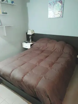 a large bed in a bedroom with a night stand at Lunita de Alberdi in Cordoba