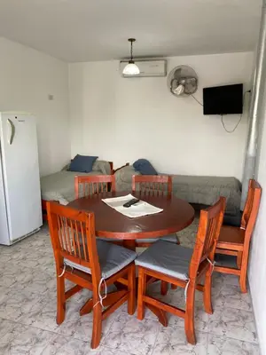 a dining room table with four chairs and a couch at Abdulle Complejo Turistico Centro in Villa Cura Brochero