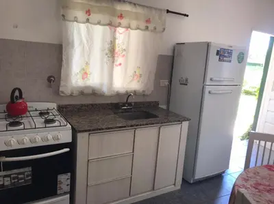a kitchen with a sink and a stove and a refrigerator at Abdulle Complejo Turistico Centro in Villa Cura Brochero