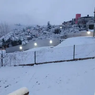 a snow covered field with a city in the background at Depto en la Sierra!! Barrio Villa del Lago con vista a los Gigantes in Villa Carlos Paz