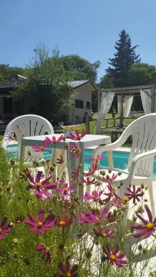 three chairs and a table and flowers in the grass at las brisas casas de campo un lugar para soñar in San Antonio de Arredondo