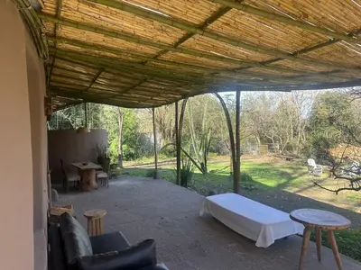 a covered patio with a bed and chairs and tables at casa cupulas in Cordoba