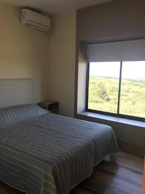 a bedroom with a bed and a large window at Cabaña La Alemana in Villa Berna