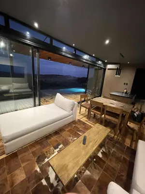 a living room with a white couch and a table at Cabaña La Alemana in Villa Berna