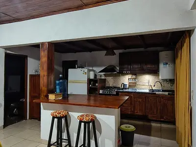 a kitchen with a counter and two bar stools at Casa con Gran Patio in Villa Parque Siquiman