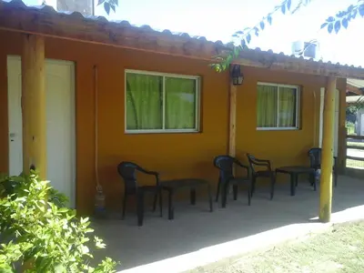 a group of chairs sitting on the porch of a house at LUMALU Deptos in Villa Cura Brochero