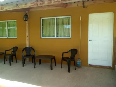 a group of chairs sitting in front of a wall at LUMALU Deptos in Villa Cura Brochero