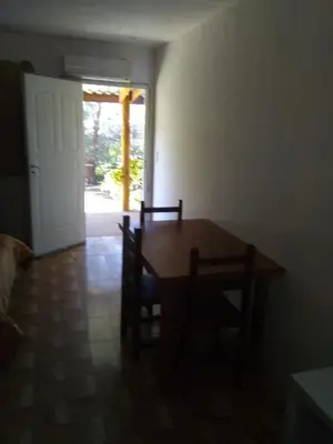 a dining room with a table and chairs and a door at LUMALU Deptos in Villa Cura Brochero