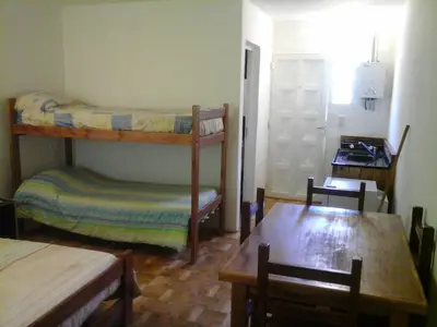 a room with two bunk beds and a table at LUMALU Deptos in Villa Cura Brochero