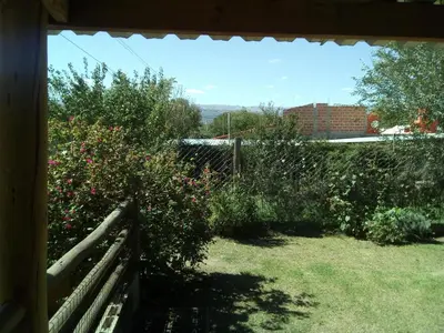 a window view of a garden with flowers and a fence at LUMALU Deptos in Villa Cura Brochero