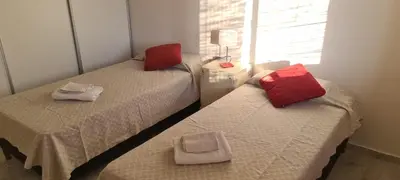 two beds in a room with red pillows on them at Carlos Paz - 3 Dormitorios con cochera - Zona céntrica residencial in Villa Carlos Paz