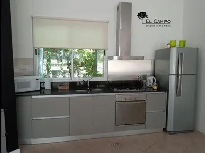 a kitchen with a stainless steel refrigerator and a sink at El Campo Departamentos in Merlo