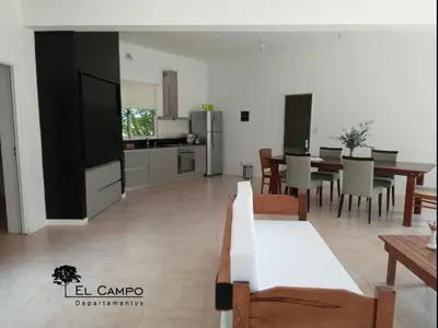 a living room with a kitchen and a dining room at El Campo Departamentos in Merlo