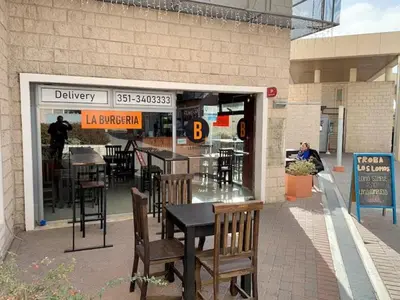 a restaurant with tables and chairs in front of a building at Departamento 1 dormitorio en complejo con amenities - Córdoba Ciudad in Cordoba