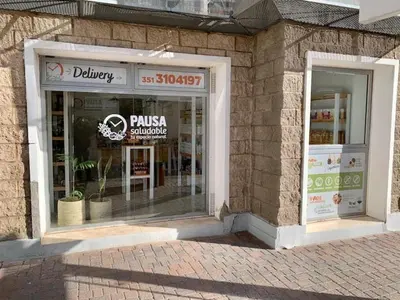 a store front of a brick building with a pizza shop at Departamento 1 dormitorio en complejo con amenities - Córdoba Ciudad in Cordoba
