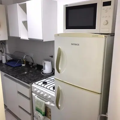 a kitchen with a microwave on top of a refrigerator at AYACUCHO APART. in Cordoba