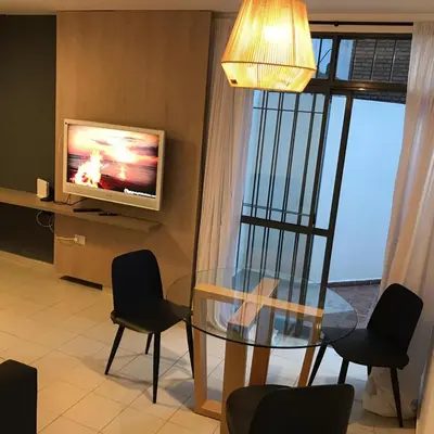a dining room with a glass table and a television at AYACUCHO APART. in Cordoba