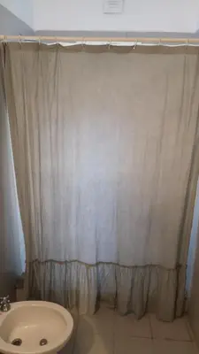 a bathroom with a shower curtain and a toilet at AYACUCHO APART. in Cordoba