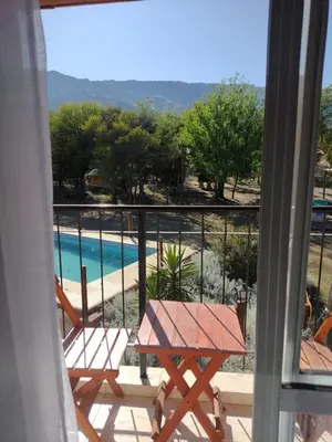 a balcony with a table and chairs and a swimming pool at LUNA DE MERLO in Merlo
