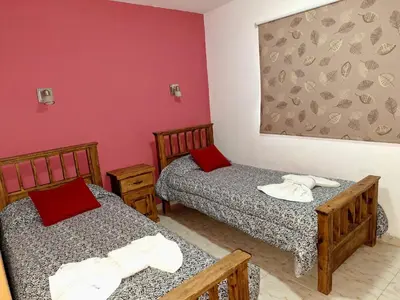 two beds in a small room with red walls at LUNA DE MERLO in Merlo
