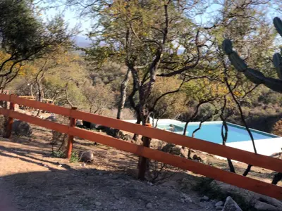 a wooden fence with a pool in the woods at ACHIRAS SUNSET in San Javier