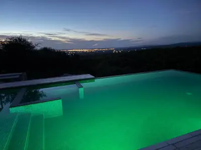 a large swimming pool with green lighting at night at ACHIRAS SUNSET in San Javier