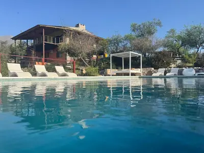 a swimming pool with chairs and a house in the background at ACHIRAS SUNSET in San Javier