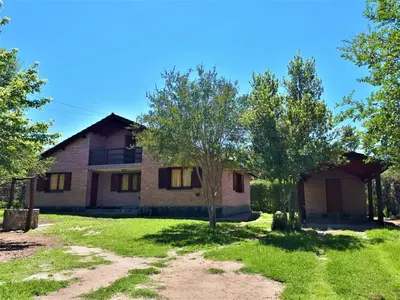 an old house with a tree in front of it at El jagüel in Villa General Belgrano