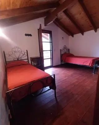 a bedroom with two beds in a room with wooden floors at El jagüel in Villa General Belgrano