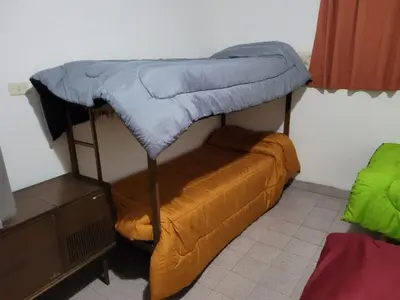 a dorm room with a bunk bed and a couch at El Remanso Estadia Minima 2 Noches in Cordoba
