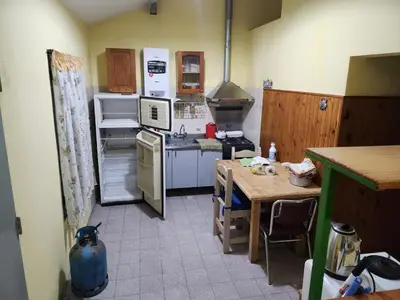 a kitchen with a table and a stove and a refrigerator at El Remanso Estadia Minima 2 Noches in Cordoba
