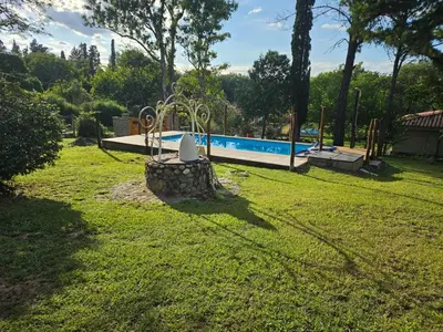 a yard with a swimming pool in the background at El Remanso Estadia Minima 2 Noches in Cordoba