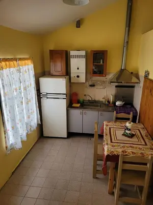 a small kitchen with a white refrigerator and a table at El Remanso Estadia Minima 2 Noches in Cordoba