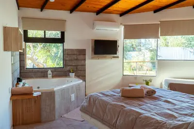 a bedroom with a bed and a tub and a television at Complejo Quiya - Departamento Los Espinillos con hidromasaje in Alta Gracia